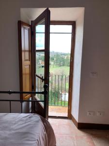 - une chambre avec une porte s'ouvrant sur un balcon dans l'établissement Casa vacanza vicolo degli orti, à Monticiano