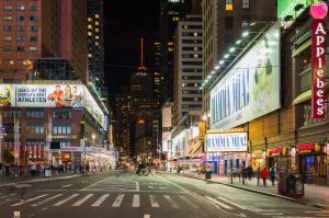 une rue urbaine vide la nuit avec des bâtiments dans l'établissement Holiday Inn Express - Times Square, an IHG Hotel, à New York