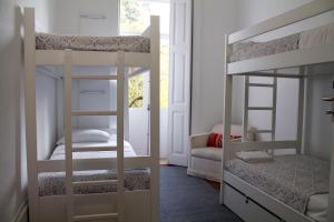 a room with two bunk beds and a window at WW Hostel & Suites in Coimbra