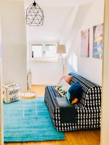 ein Wohnzimmer mit einem schwarz-weißen Sofa und einem Tisch in der Unterkunft Cozy City Apartment - by Nahuen Suites in Graz