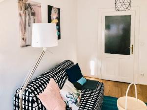 Cozy City Apartment - by Nahuen Suites في غراتس: غرفة معيشة مع أريكة سوداء وبيضاء ومصباح