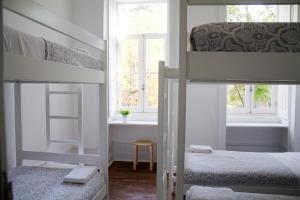 a bedroom with two bunk beds and a window at WW Hostel & Suites in Coimbra