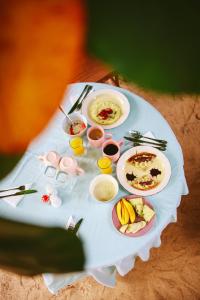 a white table with plates of food on it at Siri Beach Lodge in Nungwi