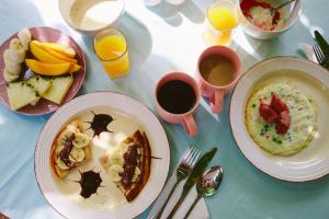 a table with two plates of food and two cups of coffee at Siri Beach Lodge in Nungwi