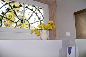 a vase with yellow flowers sitting on a window sill at WW Hostel & Suites in Coimbra