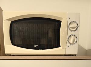 a microwave oven sitting on top of a shelf at 2 · High-Quality in the heart of Stuttgart 2 in Stuttgart