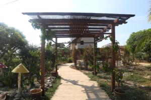 a wooden pathway in a garden with a wooden pergola at Inapan Taman Herba in Kepala Batas