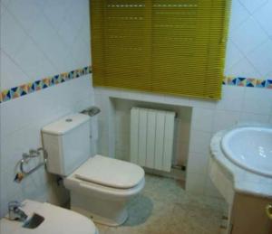 a bathroom with a white toilet and a sink at Villa Tito in Cunit +21 photos