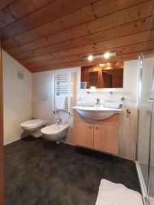a bathroom with two sinks and two toilets at Haus Bergfrieden in Castelrotto +31 photos