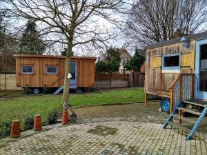 ein winziges Haus in einem Garten neben einem Baum in der Unterkunft B&B Dream On Wheels in Lommel