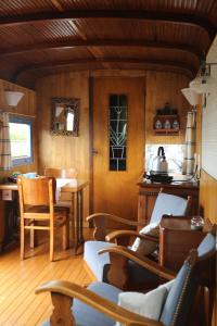 a living room with wooden floors and a table and chairs at B&B Dream On Wheels in Lommel