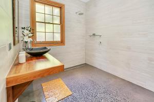 baño con lavabo y ventana en Blackwood Park Cottages Mole Creek, en Mole Creek