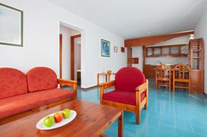 sala de estar con sofá y mesa con una bandeja de fruta en Aparthotel Costa Mar, en Puerto del Carmen