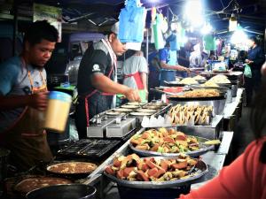 Pantai Regal Hotel في كُوانتان: مجموعة من الناس يعدون الطعام في مطبخ