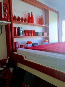 una habitación con jarrones rojos sentados en estanterías en Le Bâbord - petit studio moderne et bien équipé à 30 m de la mer, en Palavas-les-Flots