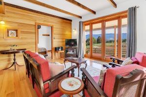 un soggiorno con divano, sedie e TV di Blackwood Park Cottages Mole Creek a Mole Creek