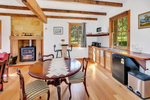 una cucina e una sala da pranzo con un tavolo di legno di Blackwood Park Cottages Mole Creek a Mole Creek