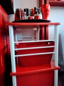 una nevera roja con un estante rojo en la cocina en Le Bâbord - petit studio moderne et bien équipé à 30 m de la mer, en Palavas-les-Flots