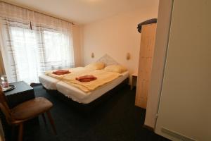 a bedroom with a bed and a chair and a window at Gasthof Zur Grafschaft Veldenz in Veldenz