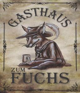 um sinal com um veado com um chapéu e árias em Gasthaus zum Fuchs - Familie Andrä em Hermagor