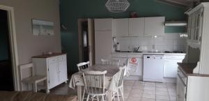 a kitchen with a table and a table and chairs at maison de dunes in Bredene