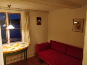 a living room with a red couch and a window at Villa Gurevitch - 4 lägenheter med sängplats för två i varje lägenhet in Urshult +1 photo