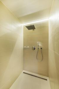 a bathroom with a shower with a shower head at Modern Apartment in a Picturesque 15th-Century Building in Prague