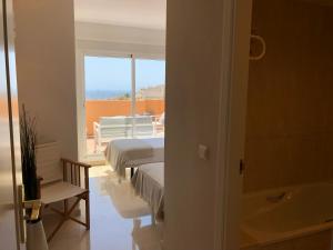 米哈斯NEW: LUXURIOUS PENTHOUSE WITH JACUZZI & SEA VIEW的客房设有两张床、一个浴缸和一个窗户。 更多23张照片