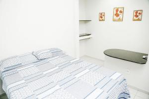 uma cama num quarto branco com uma roupa de cama espectrosespectrosspectos em Casa OhVidaBoa com 6 suítes em Natal