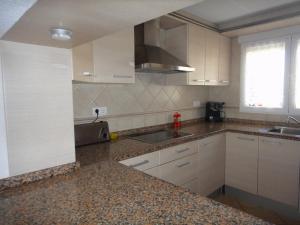 a kitchen with white cabinets and a sink at Apartamento Familiar in Balcon del Mar