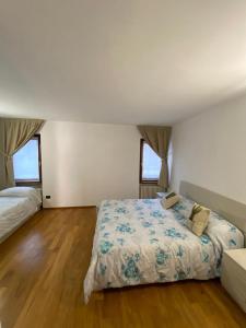 シルミオーネにあるSuite Mavino Appartamentiのベッドルーム1室(大型ベッド1台、窓2つ付)