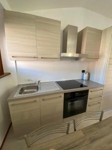 a small kitchen with white cabinets and a sink at Suite Mavino Appartamenti in Sirmione +33 photos