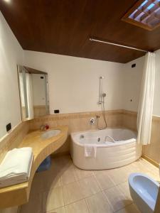 a large bathroom with a tub and a sink at Suite Mavino Appartamenti in Sirmione