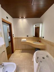 a bathroom with a bath tub and a sink at Suite Mavino Appartamenti in Sirmione