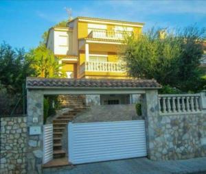a yellow house with a gate and a garage at Villa Tito in Cunit