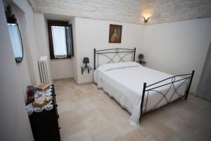 sypialnia z dużym łóżkiem w białym pokoju w obiekcie Trullo Dell’Antica Fileria w Alberobello