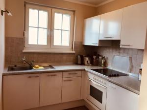 a kitchen with white cabinets and a sink at Ferienwohnung Rügen in Sagard