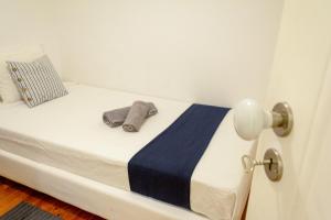 a bed with a hat and a towel on it at Guest House Amoreiras in Lisbon