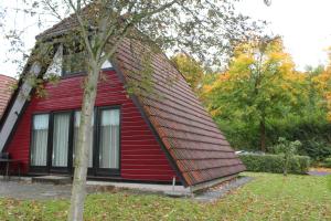 a red house with aavy roof on top of it at Ferienhaus Mohnblume in Ronshausen