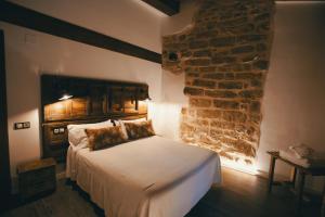 1 dormitorio con cama y pared de ladrillo en El Racó de Valderrobres, en Valderrobres