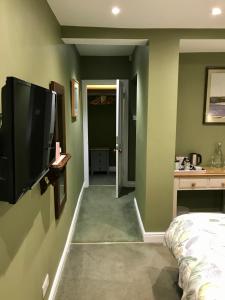 a bedroom with a flat screen tv on a wall at Dairy Guest House in York