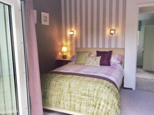 a bedroom with a bed with two pillows on it at Beech Hut - a streamside family escape near Salcombe and Beaches in South Milton