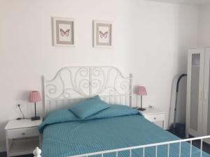 a bedroom with a bed with two night stands and two lamps at Casa Zeralda, privater Pool in Budoni +6 photos