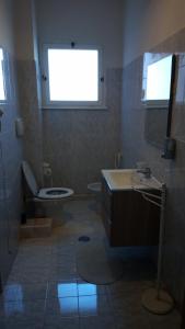 een badkamer met een toilet, een wastafel en een raam bij Giordiehouse2 in Latina