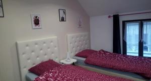 Un dormitorio con una cama con sábanas rojas y una ventana en Loc'apparts en Beaumont-sur-Oise