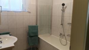 y baño con ducha, bañera y lavamanos. en Haus Luisi, en Hitzendorf