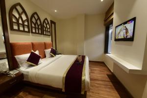 1 dormitorio con 1 cama y TV en la pared en Hotel Golden Lagoon, en Amritsar