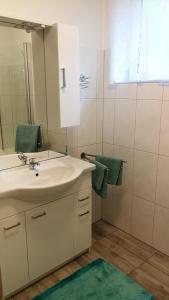 y baño con lavabo y espejo. en Haus Luisi, en Hitzendorf