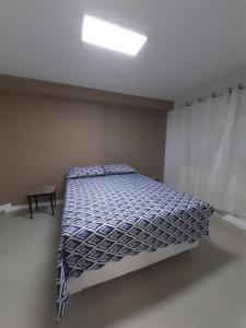 1 dormitorio con 1 cama con edredón azul y blanco en Casa Itapuca, en Niterói