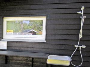 una ventana en el lateral de una casa con un banco en 6 person holiday home in Hadsund, en Odde